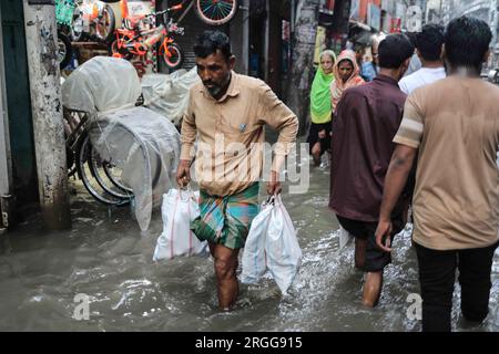 Dhaka, Bangladesh. 9 agosto 2023. La gente cammina su strade inondate dopo la pioggia al Nazira Bazar a Dacca, Bangladesh, il 9 agosto 2023. (Immagine di credito: © MD Rakibul Hasan/ZUMA Press Wire) SOLO USO EDITORIALE! Non per USO commerciale! Crediti: ZUMA Press, Inc./Alamy Live News Foto Stock