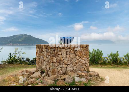 Isola di Naoshima, Giappone - 12 aprile 2023; primo piano di opere d'arte: Bevi una tazza di tè di Kazuo Katase, un'opera all'aperto al Benesse House Museum con in backgr Foto Stock