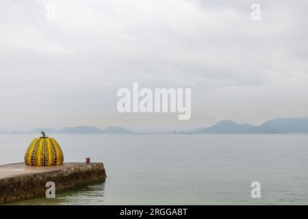 Isola di Naoshima, Giappone - 12 aprile 2023; veduta dell'iconica zucca gialla dell'artista Yayoi Kusama all'esterno del museo d'arte contemporanea Benesse House ON Foto Stock