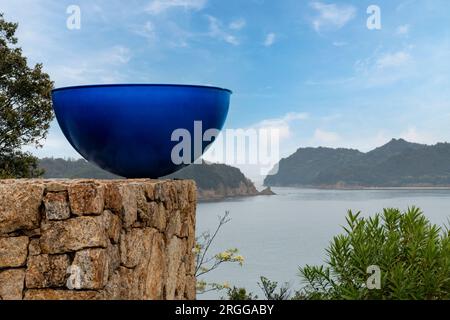 Isola di Naoshima, Giappone - 12 aprile 2023; primo piano di opere d'arte: Bevi una tazza di tè di Kazuo Katase, un'opera all'aperto al Benesse House Museum con in backgr Foto Stock