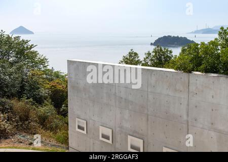 Isola di Naoshima, Giappone - 12 aprile 2023; all'esterno della fiera si affacciavano su mura di cemento del museo d'arte contemporanea Benesse House con il Mare interno di Seto a bac Foto Stock