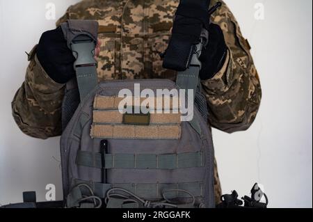 Soldato ucraino in pixel militare mimetico con gilet antiproiettile grigio in armi e bandiera di bandiera Ucraina. Foto Stock