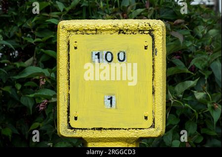 Numeri da 1 a 100 su un cartello giallo dell'idrante Foto Stock