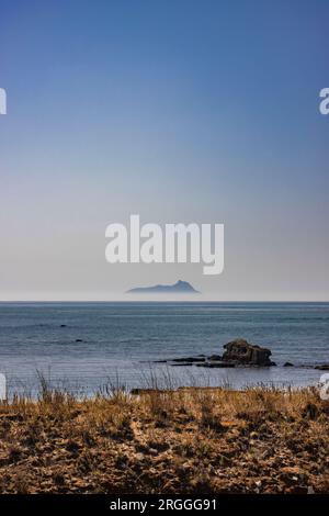 Ponza, Italia. La silhouette dell'isola che emerge dalla nebbia, vista dalla costa laziale in lontananza. Foto Stock