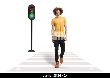 Ritratto a figura intera di un giovane con capelli ricci che attraversa una strada isolata su sfondo bianco Foto Stock