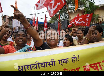 Mumbai, India. 9 agosto 2023. I manifestanti tengono uno striscione e delle bandiere durante una protesta contro la riqualificazione di Dharavi (la più grande colonia di baraccopoli dell'Asia) da parte dell'Adani Group a Mumbai. I residenti che vivono e gestiscono aziende locali a Dharavi per anni sentono che la riqualificazione li porterà via e il gruppo Adani sfrutterà il posto per i propri profitti, trasformandolo in un parco giochi per i ricchi. Credito: SOPA Images Limited/Alamy Live News Foto Stock