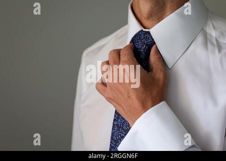 uomo che stringe la cravatta il giorno del suo matrimonio Foto Stock