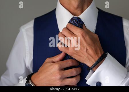 uomo che stringe la cravatta il giorno del suo matrimonio Foto Stock