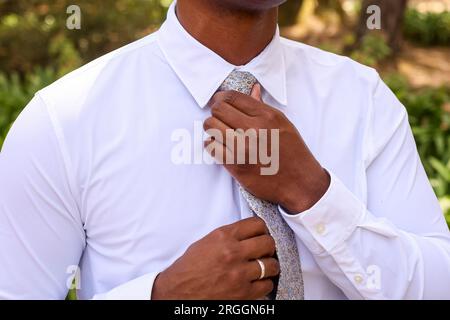 uomo che stringe la cravatta il giorno del suo matrimonio Foto Stock