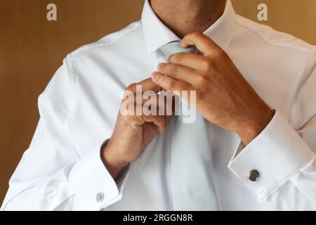 uomo che stringe la cravatta il giorno del suo matrimonio Foto Stock