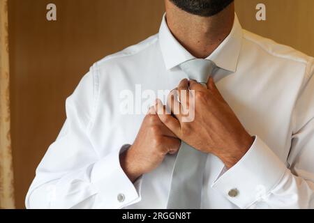 uomo che stringe la cravatta il giorno del suo matrimonio Foto Stock