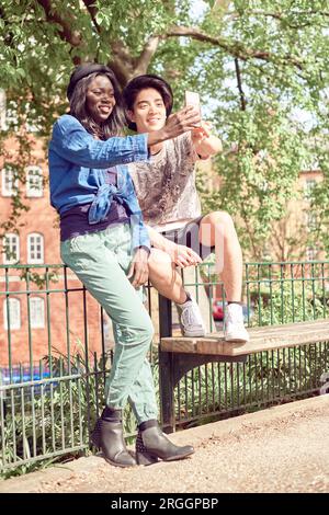 Giovane adolescente tenendo selfie in park insieme Foto Stock