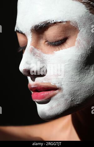 Giovane donna che indossa la maschera per il viso Foto Stock