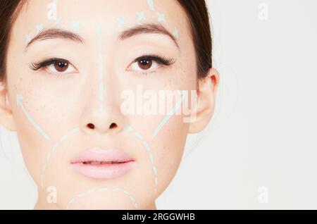 Giovane donna con le linee tracciate sulla faccia Foto Stock