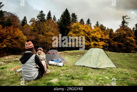 Giovane donna parlando con un amico in campeggio Foto Stock