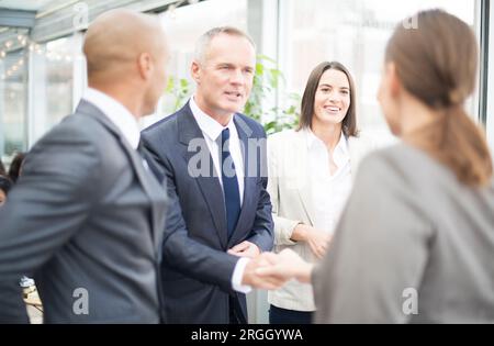 Gli imprenditori si stringono la mano dalla finestra Foto Stock