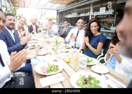 Gli imprenditori ad applaudire durante la riunione presso il ristorante Foto Stock