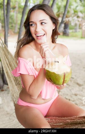 Giovane donna con drink di noce di cocco in Ko Samui, Tailandia Foto Stock