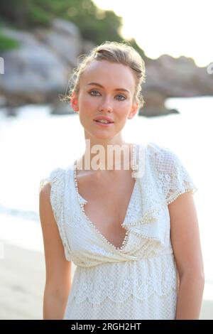 Giovane donna indossa bianco sulla spiaggia Foto Stock