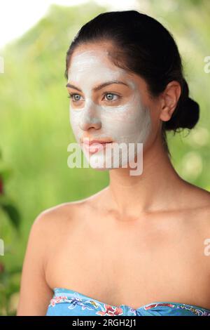 Giovane donna che indossa la maschera per il viso Foto Stock