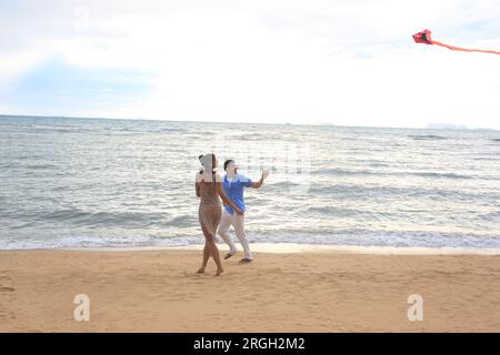 Coppia giovane aquilone volante sulla spiaggia Foto Stock