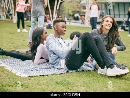 Amici di adolescenti seduti sulla coperta picnic Foto Stock