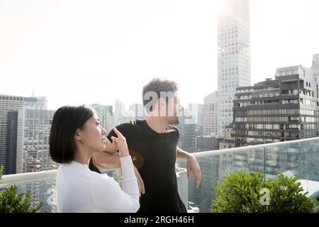 Coppia giovane sul balcone nella città di New York Foto Stock