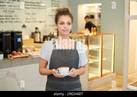 Barista azienda caffè nella caffetteria Foto Stock