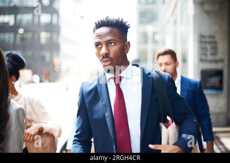 Giovane uomo d'affari che cammina per strada cittadina Foto Stock