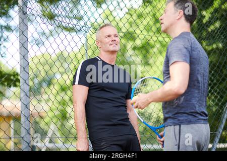 Uomini maturi sul campo da tennis Foto Stock