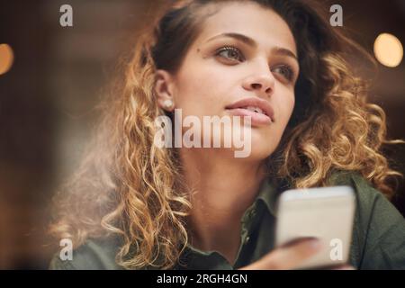 Ritratto di giovane donna azienda smart phone Foto Stock