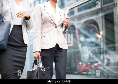 Donne d'affari che camminano sul marciapiede Foto Stock