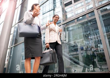 Donne d'affari che camminano sul marciapiede Foto Stock