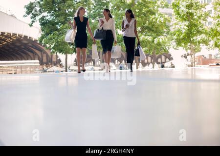 Donne d'affari che camminano sul marciapiede Foto Stock