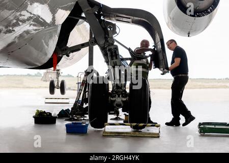 Uomini che lavorano sulla ruota dell'aereo Foto Stock