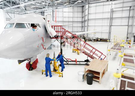 Lavoratori in hangar aereo Foto Stock