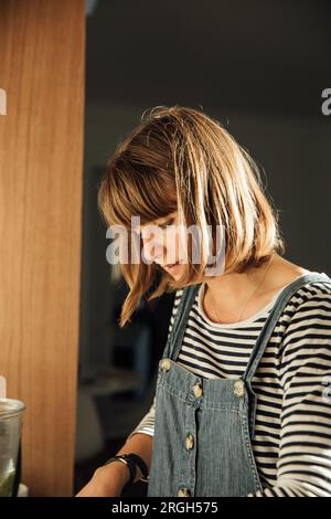 Giovane donna con taglio di capelli che guarda in basso Foto Stock