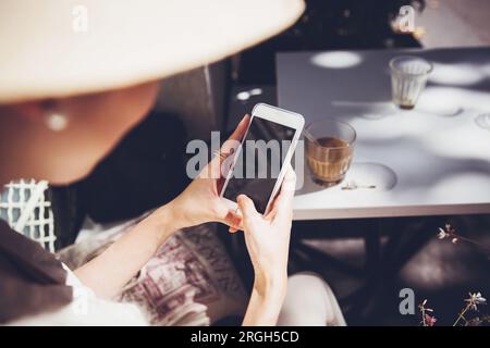 Vista a spalla di una donna che tiene uno smartphone Foto Stock