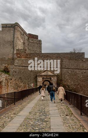 Il turista attraversa il Ponte di San Giorgio per raggiungere la Fortezza Priamar (1542), costruita dalla Repubblica di Genova, Savona, Liguria, Italia Foto Stock