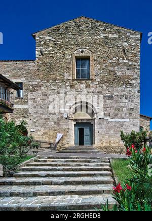 Bevagna, Umbria, Italia. La chiesa di San Francesco (1275) sorge su una collina sotto un cielo azzurro, raggiungibile da una scala fiancheggiata da aiuole. Foto Stock