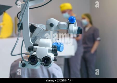 Microscopio chirurgico in sala operatoria con medici. Clinica oftalmologica Foto Stock