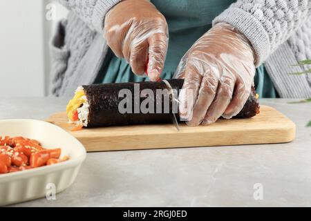 Riso kimbap Korean Roll con coltello. Preparazione di Gimbap, kimbap tagliato, gimbap coreano. Step by Step Making Kimbop Foto Stock