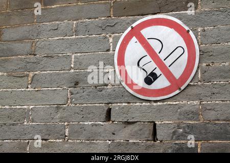 Cartello di divieto di fumo sul muro rotto Foto Stock