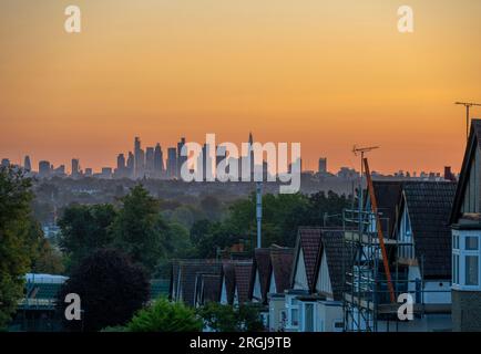 Wimbledon, Londra, Regno Unito. 10 agosto 2023. Temperature a Londra dovute al picco a 25 gradi piacevoli oggi. Un cielo arancione all'alba con i grattacieli del centro di Londra che catturano i primi raggi di luce solare. Crediti: Malcolm Park/Alamy Live News Foto Stock