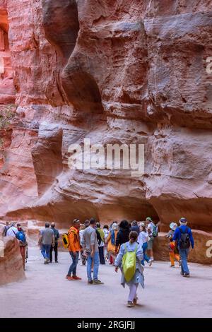 Petra, Giordania - 3 novembre 2022: Gente turisti che camminano lungo le mura di Siq al Tesoro, al Khazneh, una delle nuove sette meraviglie del mondo Foto Stock