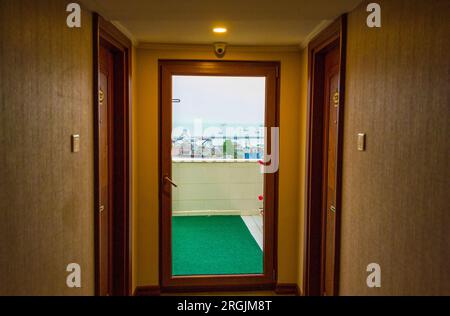 Vista panoramica dal corridoio dell'hotel attraverso la porta di vetro sui tetti della città vecchia di Istanbul fino alle navi ormeggiate nel Mare di Marmara da Yenikapi Fast Foto Stock