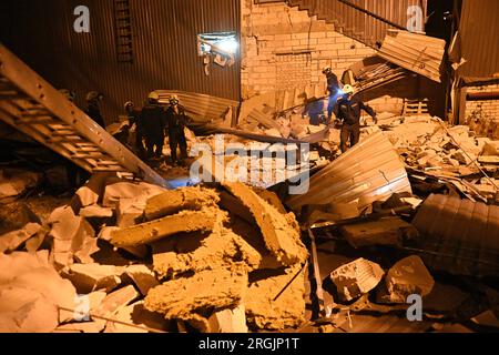 ZAPORIZHZHIA, UCRAINA - 9 AGOSTO 2023 - i soccorritori sono visti al lavoro sul luogo di un attacco missilistico russo che ha avuto luogo mercoledì sera, agosto Foto Stock