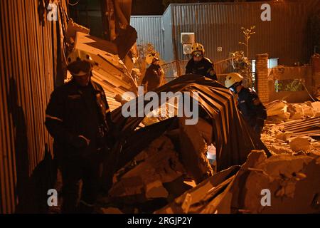 ZAPORIZHZHIA, UCRAINA - 9 AGOSTO 2023 - i soccorritori sono visti al lavoro sul luogo di un attacco missilistico russo che ha avuto luogo mercoledì sera, agosto Foto Stock