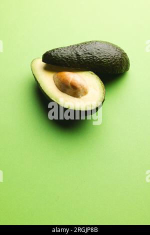 Primo piano di due metà di avocado e spazio di copia su sfondo verde Foto Stock