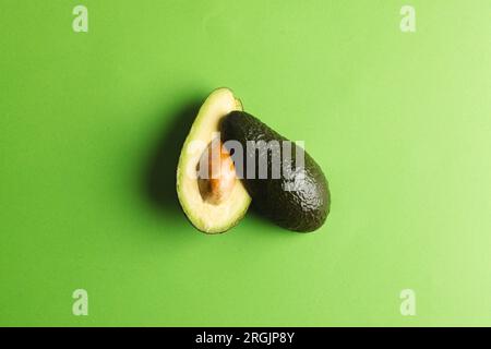 Primo piano di due metà di avocado e spazio di copia su sfondo verde Foto Stock